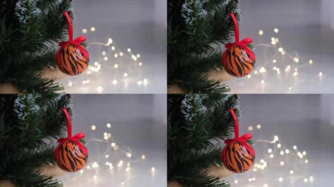 用花环在圣诞树上画成老虎条纹的圣诞球。2022是虎年。新年快乐。圣诞舞会上农历老虎的象征。
