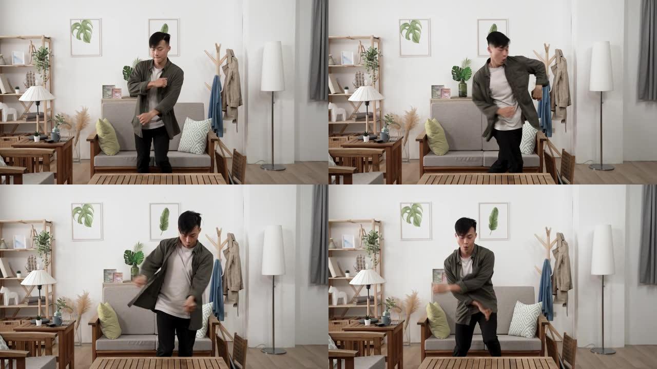 前视图，慢动作活跃的亚洲男性年轻成年人在白天在他的现代公寓里跳舞时，在原地打转。