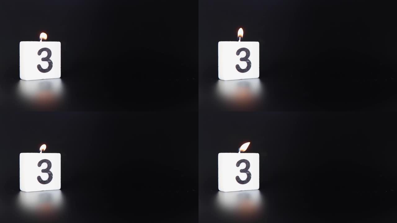 一根方形蜡烛，上面写着数字3被点燃并吹出，庆祝生日或周年纪念日。