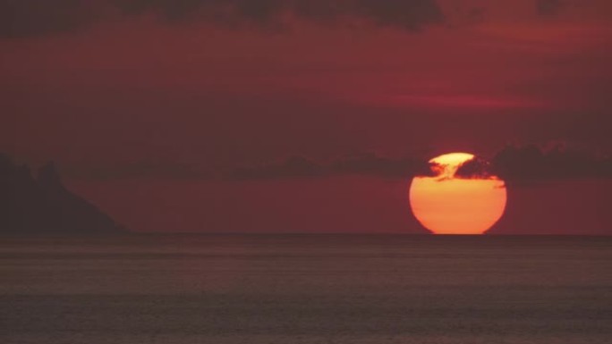 壮丽的神秘血红色的海洋日落。巨大的南方太阳坐在海洋地平线后面