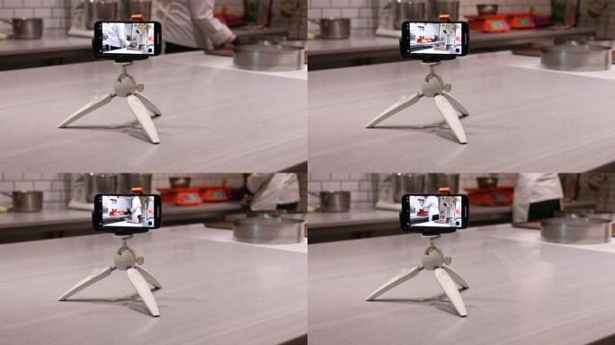 一位女厨师正在做饭时用手机录制自己的视频。