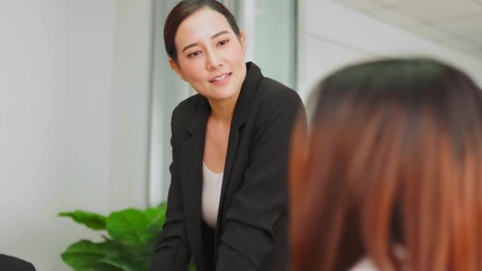 亚洲女性团队负责人向同事提出问题解决策略。企业员工集团业务研讨会上的行政领导培训专业团队。头脑风暴会