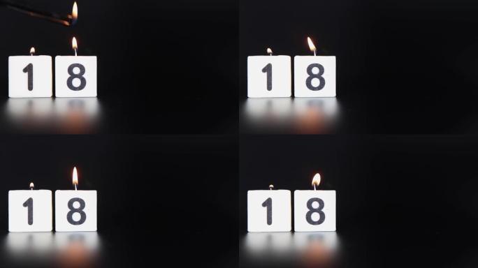一根方形蜡烛，上面写着数字18被点燃并吹出，庆祝生日或周年纪念日。