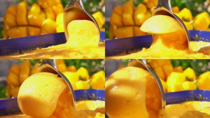 勺子在成熟芒果的背景下舀冷冻芒果冰淇淋冰淇淋