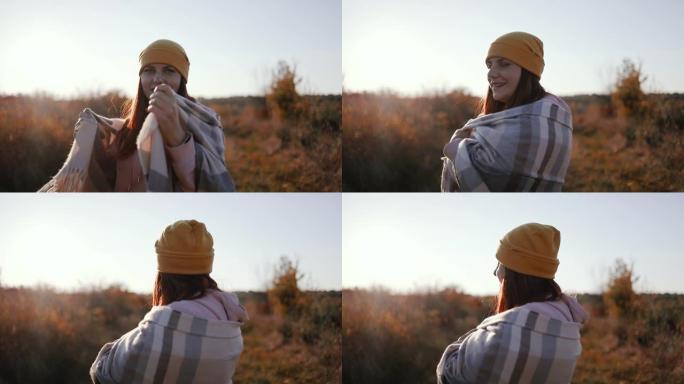 戴着黄色帽子和舒适的羊绒围巾的快乐自由女人在秋季公园户外玩得开心