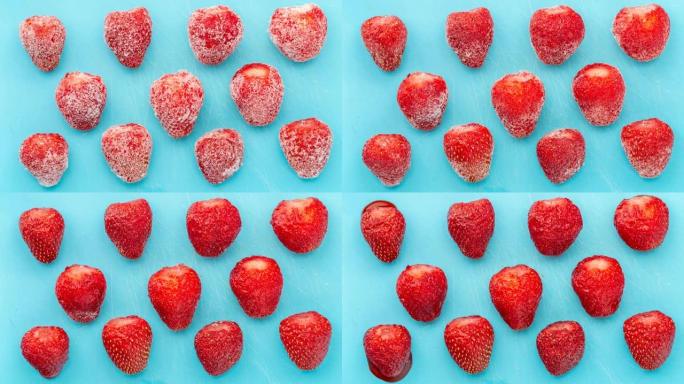 冷冻草莓在蓝色背景上解冻。冬天收获水果和浆果。冷冻食品特写。时间流逝。