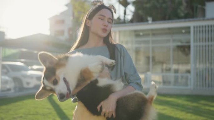 幸福在一起有吸引力的亚洲女性年轻成年女性喜欢在户外草场后院和可爱的柯基狗一起玩