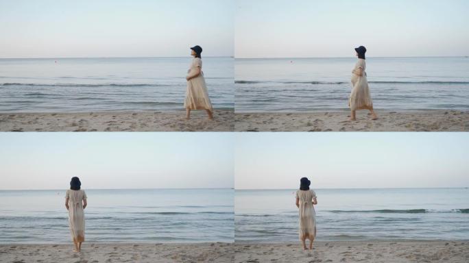 亚洲孕妇在沙滩上散步