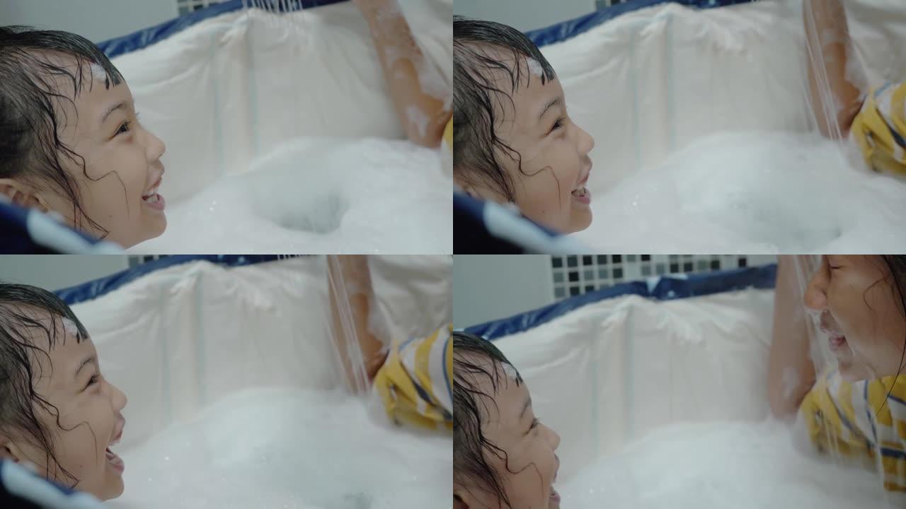 亚洲孩子一起在塑料迷你浴缸里玩泡泡，生活理念。