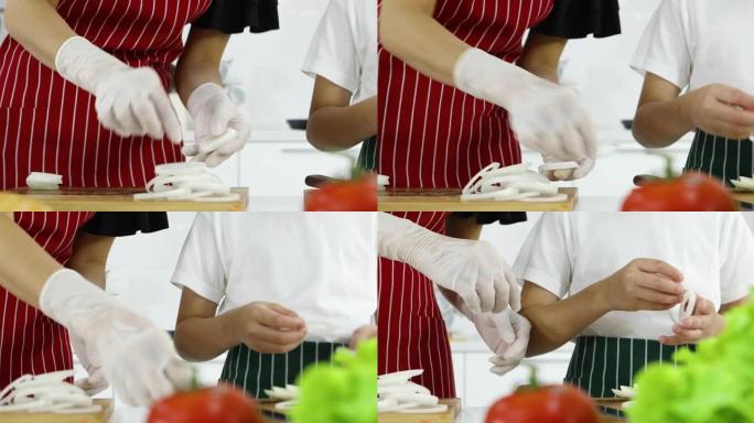 母亲教年幼的小儿子如何在现代白色调厨房里准备洋葱做汉堡。家庭中爱与关系的概念。