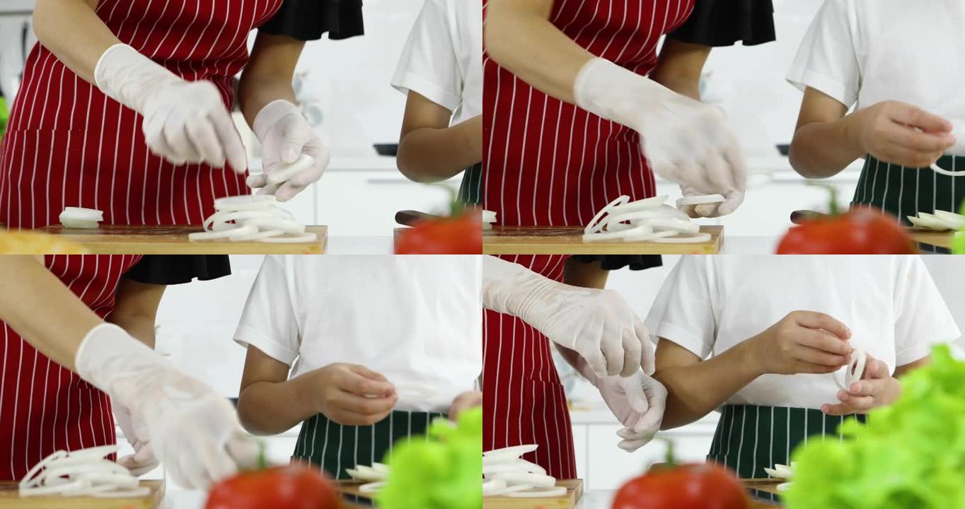 母亲教年幼的小儿子如何在现代白色调厨房里准备洋葱做汉堡。家庭中爱与关系的概念。