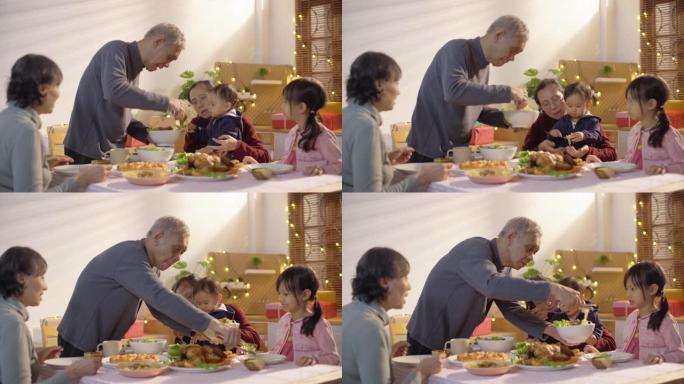 祖父母和孙子一起吃饭或吃饭，坐在一张可爱的桌子旁，参加假日聚会，互相提供食物