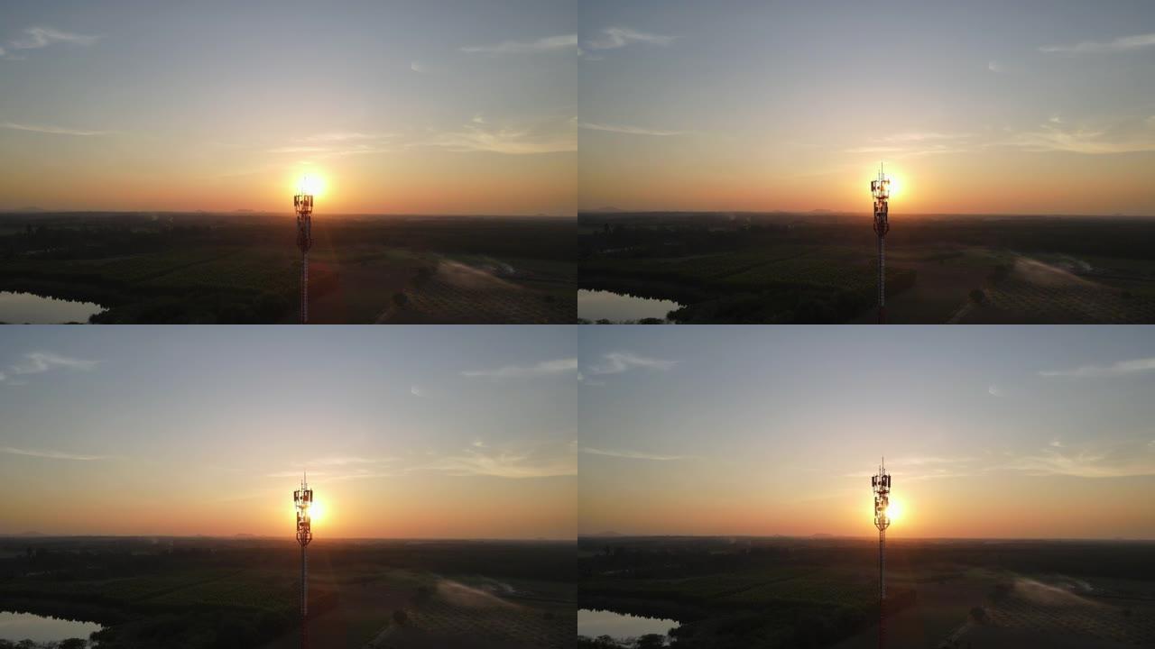 电信塔的鸟瞰图，天线对着日落的天空。