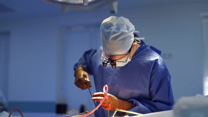 专业医生在手术过程中使用手术工具。医疗制服的神经外科医生在进行手术时戴着带有显微镜镜片的眼镜。
