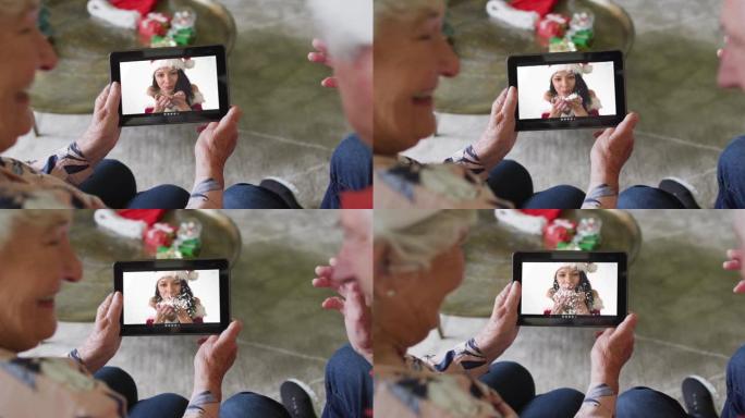 高级高加索夫妇使用平板电脑与屏幕上的幸福女人进行圣诞节视频通话