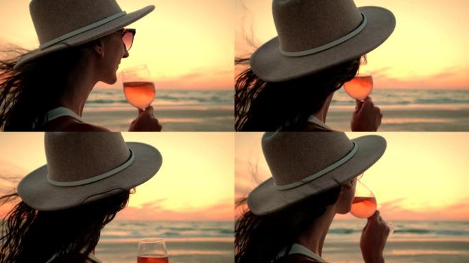 举行葡萄酒课的女人看着海洋上的日落，欣赏着令人惊叹的景色