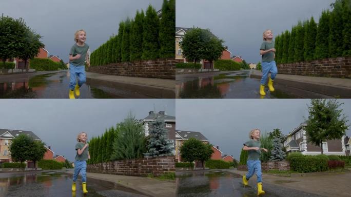 在小镇的雨天，小男孩穿着黄色橡胶靴在水坑中奔跑跳跃的慢动作视频。孩子玩得开心。