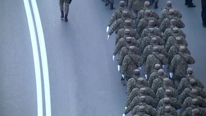 身着迷彩服、戴着白手套的士兵在阅兵式上行进