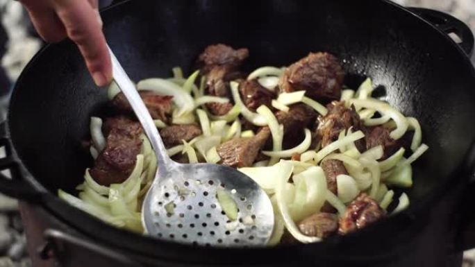 将洋葱和肉混合在大锅中，用于乌兹别克抓饭