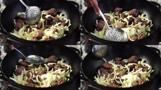 将洋葱和肉混合在大锅中，用于乌兹别克抓饭