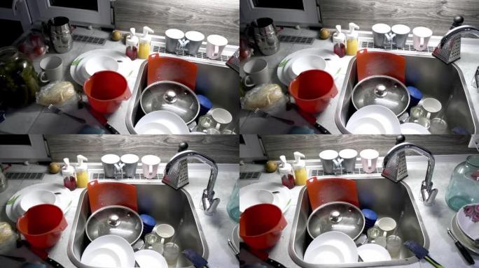 4K.桌子上和厨房水槽里一堆脏盘子。剩下的食物里有盘子。例行作业。客人后的清洁概念。一个非常蓬乱的房