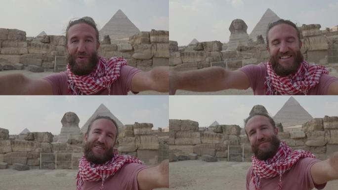 慢动作: 年轻人旅行在吉萨大金字塔前自拍。男性在埃及开罗与金字塔和狮身人面像一起自拍