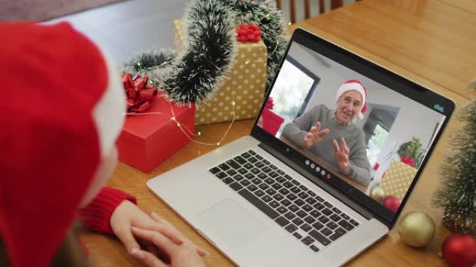 快乐的白人妇女在圣诞节与祖父进行视频通话
