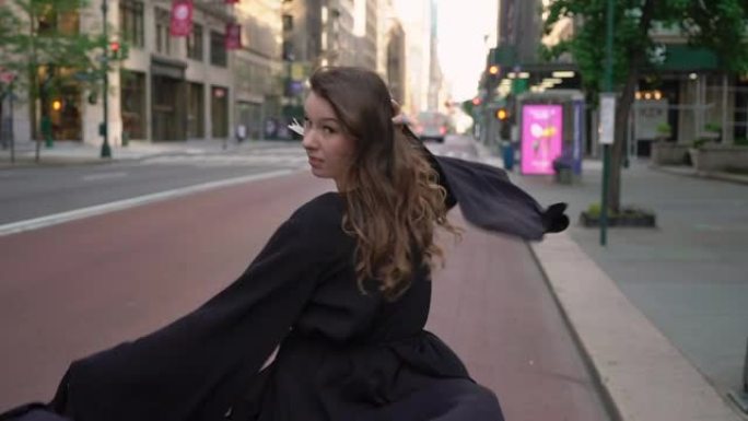 穿着黑色长裙的女孩穿过纽约曼哈顿的街道