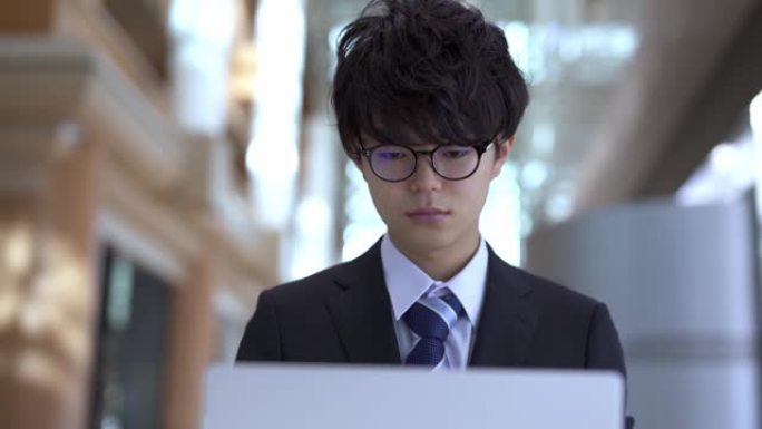 亚洲男子使用笔记本电脑打字