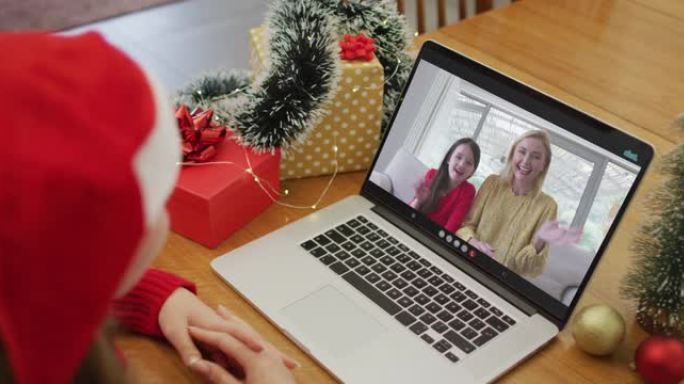 快乐的白人妇女在圣诞节与女性朋友和她的女儿进行视频通话