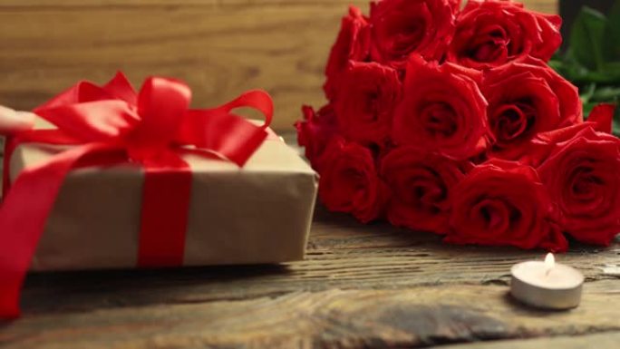 心爱的礼品盒束红玫瑰燃烧蜡烛木桌情人节