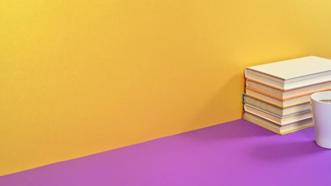 一堆精装复古书籍和一杯咖啡出现在紫色金色主题上。停止运动