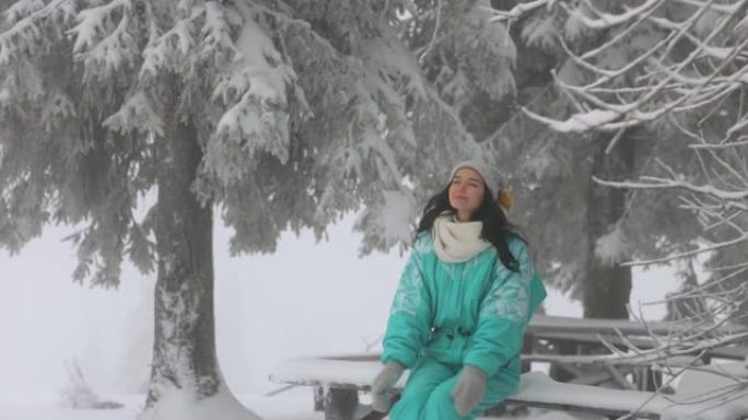 在户外寒假期间，穿着滑雪服的女人在白雪皑皑的森林里