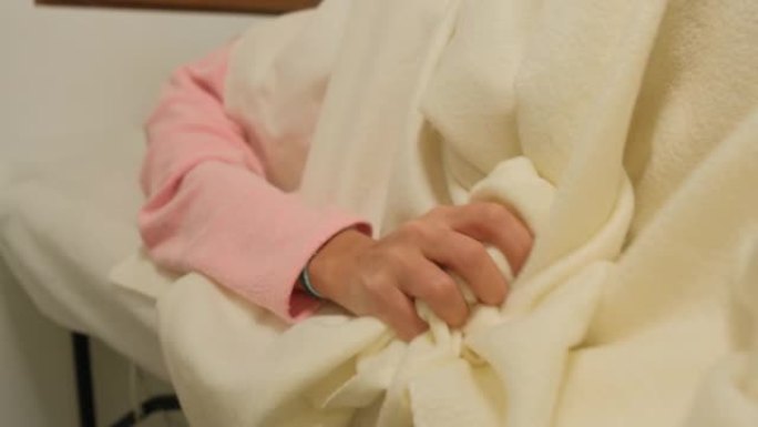 一个怀孕的女孩分娩了。该名女子宫缩，她用手特写紧紧抓住床。