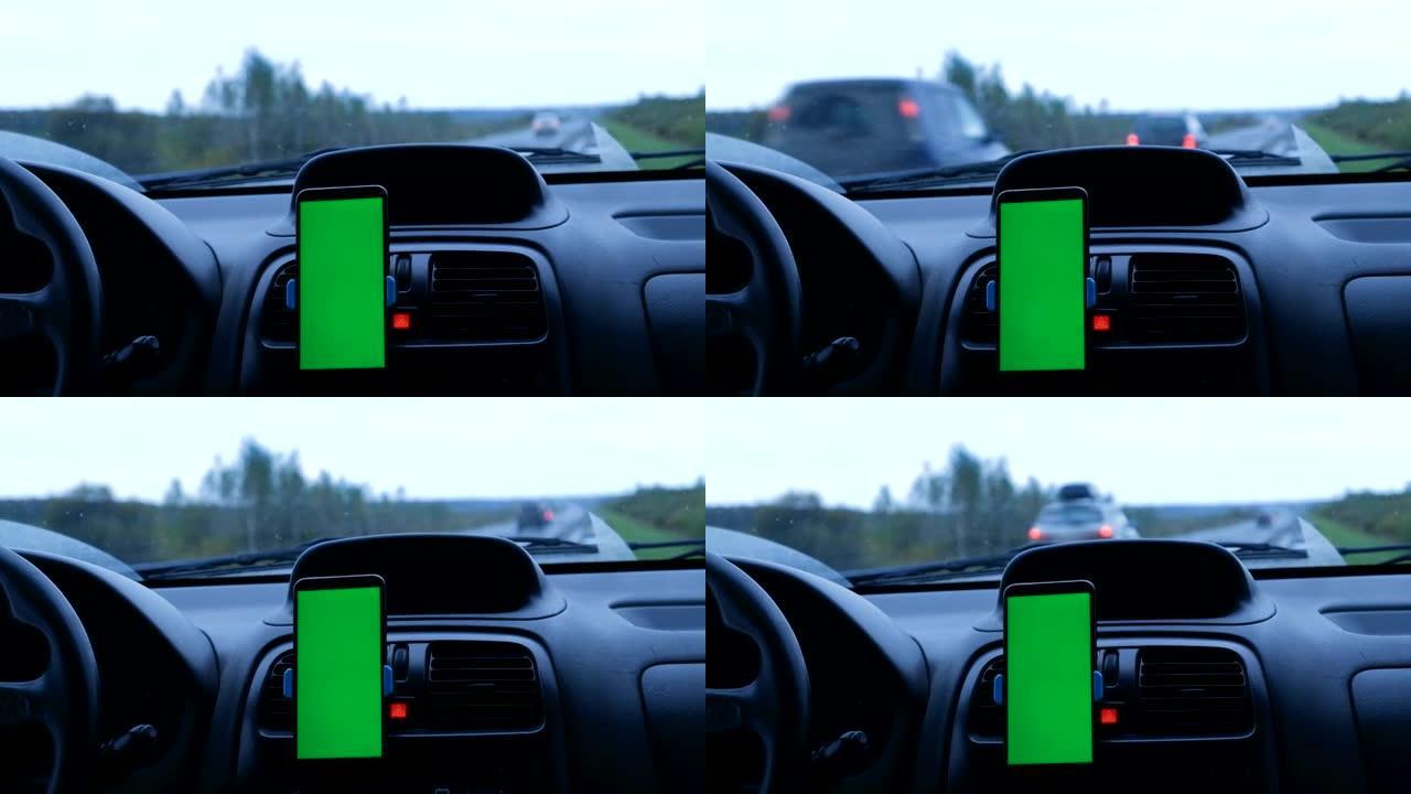 用于内容嵌入的绿屏手机安装在停在道路上的汽车内部的面板上