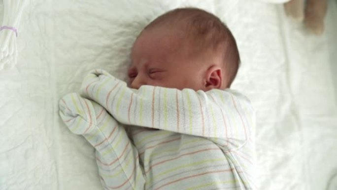 清醒的新生儿面部肖像痤疮过敏刺激早期白色背景上的鬼脸。孩子在帽子上开始生命的几分钟。婴儿，分娩，出生