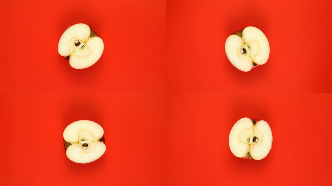 俯视图: 一半的苹果在红色表面上旋转-慢动作