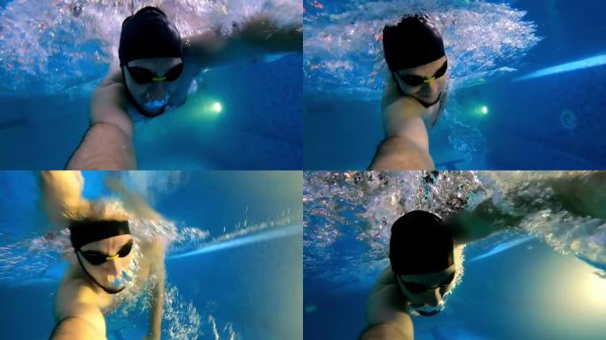 戴防水眼镜的年轻人手里拿着相机在水下游泳