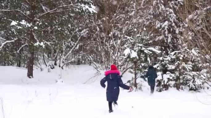 散焦男孩和一个女孩雕刻雪球。有趣的孩子在冬季公园玩雪球，积极地花时间在户外冬季白雪皑皑的林地寒冷的霜