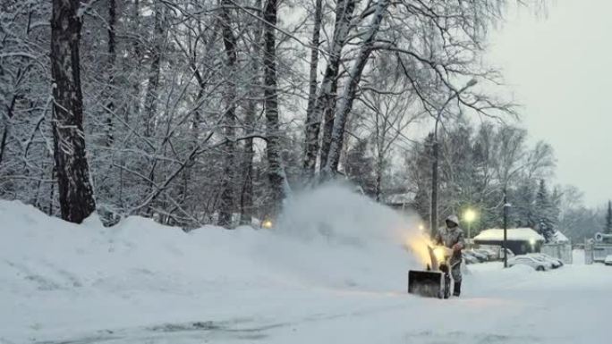 冰雪覆盖的男子冬季用鼓风机、除雪设备清理道路