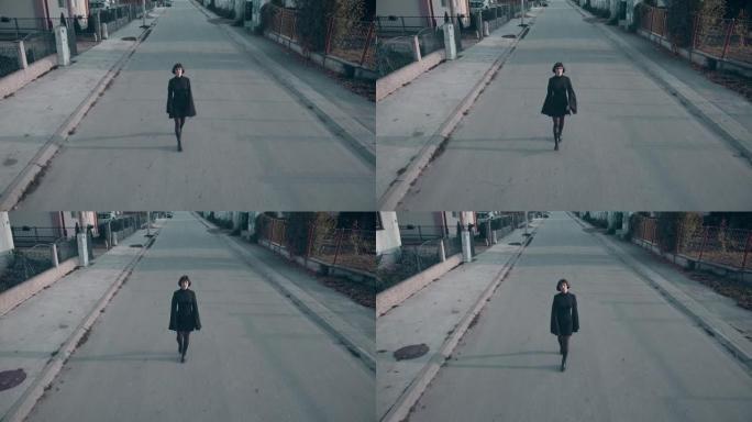 一名身穿黑衣的年轻女子走在城市街道上，慢动作无人机拍摄