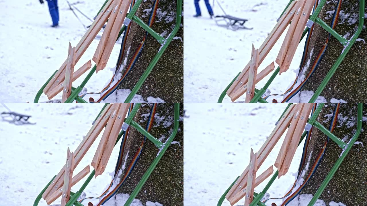 孩子们在雪橇骑山的混凝土垃圾箱留下的破损的木制座椅上损坏了雪雪橇