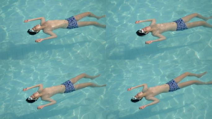 快乐的亚洲男孩在度假期间漂浮在游泳池里，在酒店或度假村里，带着家庭生活方式的概念。