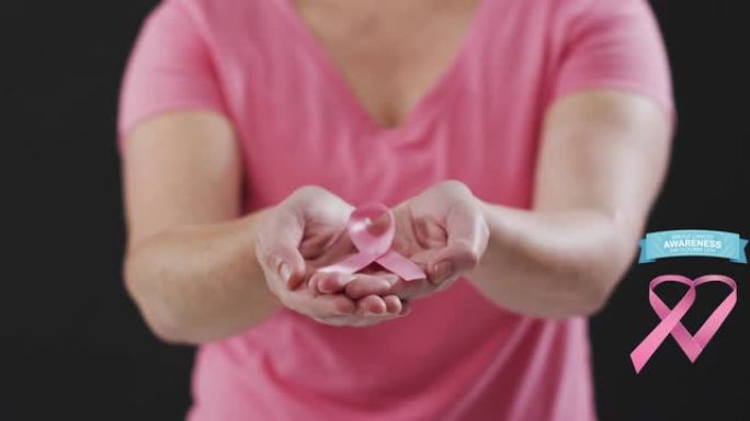 乳腺癌意识文字横幅反对手持粉红丝带的女性的中部