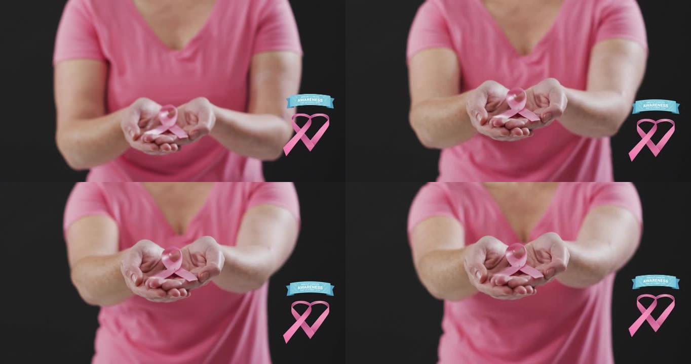乳腺癌意识文字横幅反对手持粉红丝带的女性的中部