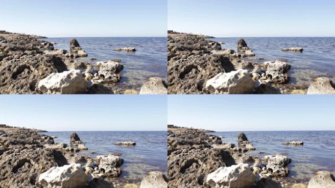 平静的大海，岸边有大尖锐的岩石