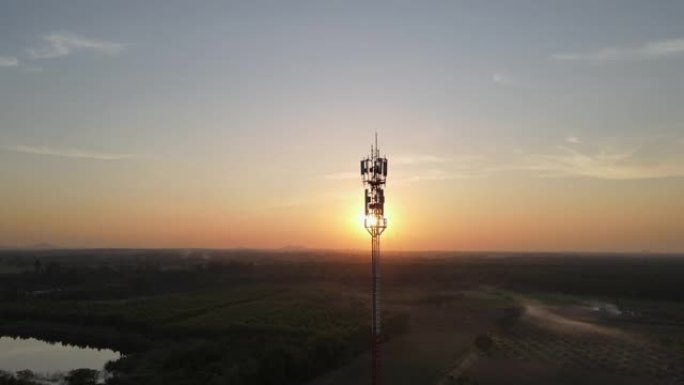 电信塔的鸟瞰图，天线对着日落的天空。