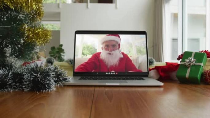 带有圣诞老人服装的白人男子在笔记本电脑上的圣诞节视频通话