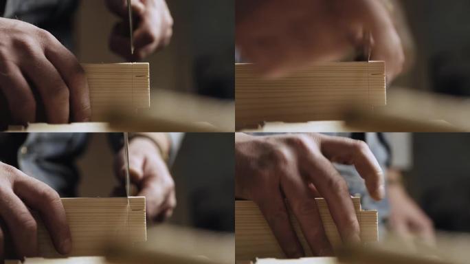 特写。木匠用手锯在木板上切出燕尾榫。木工做燕尾榫