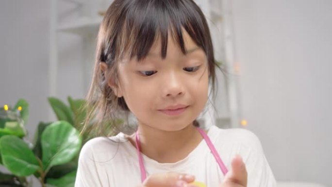 微笑的亚洲女孩拿着糕点面团，然后模制自制饼干庆祝圣诞节，生活方式概念。